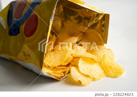 Potato chips, delicious BBQ seasoning spicy for crips, thin slice deep fried snack fast food in open bag. Potato chips, delicious BBQ seasoning spicy for crips, thin slice deep fried snack fast food in open bag. 128224823