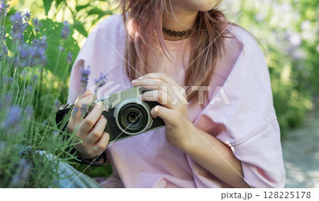 Young photographer taking pictures in a lavender field using a vintage camera 128225178