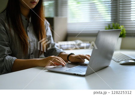 Young entrepreneur typing on laptop, working remotely or managing business tasks in a calm workspace Young entrepreneur typing on laptop, working remotely or managing business tasks in a calm workspace 128225312