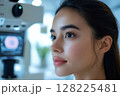 Young woman undergoing eye examination with modern equipment in clinic 128225481