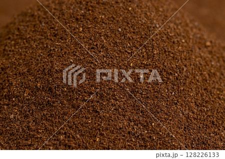 an abstract uneven background of ground coffee beans for making a high-quality and aromatic coffee drink, closeup 128226133