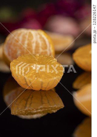 the reflection of tangerine in a mirror surface closeup, a peeled and juicy tangerine on a mirror 128226147