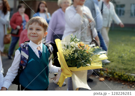 A 7-year-old boy carries a bouquet of flowers as he walks to his first day of school on September A 7-year-old boy carries a bouquet of flowers as he walks to his first day of school on September 128226281