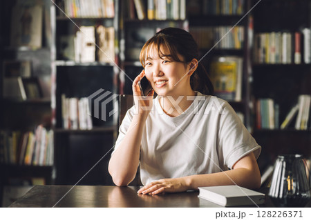 書斎,図書館で電話をする大学生の女性 128226371