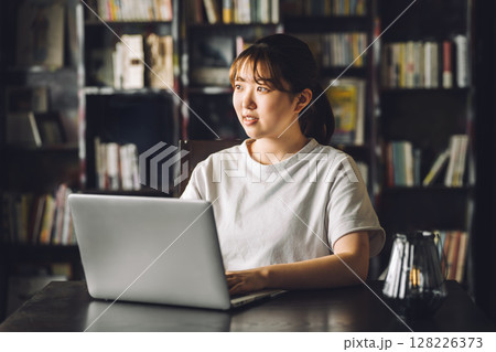 書斎,図書館でパソコンを使って読書をする大学生の女性 書斎,図書館でパソコンを使って読書をする大学生の女性 128226373