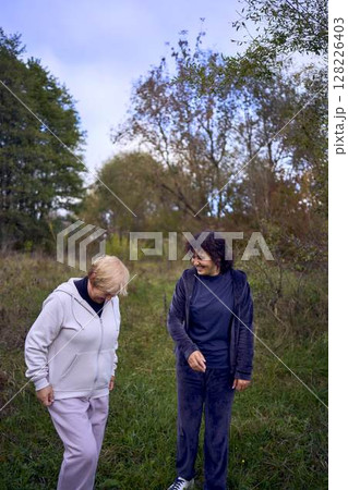 middle-aged woman and her old mother laughing during a morning jog together, for maintaining health by the river in autumn middle-aged woman and her old mother laughing during a morning jog together, for maintaining health by the river in autumn 128226403
