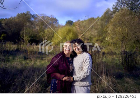 middle-aged daughter and elderly mother together on a walk in the autumn forest 128226453
