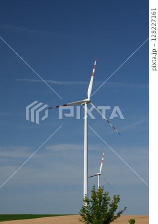 Two modern wind turbines in the countryside under a clear blue sky. Austria. 128227161