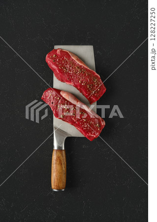 Freshly cut pieces of beef on a large cleaver ready for cooking in a kitchen Freshly cut pieces of beef on a large cleaver ready for cooking in a kitchen 128227250