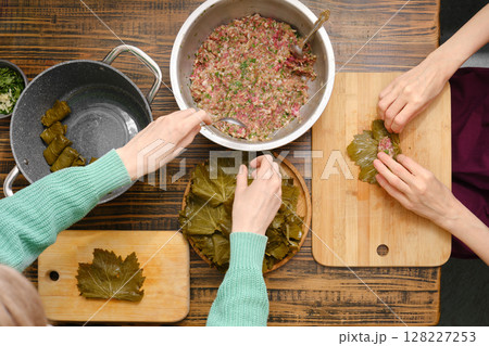Preparing traditional dolma with seasoned meat and grape leaves in a cozy kitchen 128227253