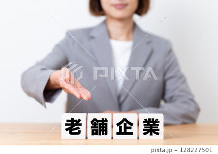 老舗企業のブロックとスーツを着たミドル女性ビジネスウーマン 老舗企業のブロックとスーツを着たミドル女性ビジネスウーマン 128227501