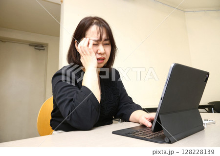 パソコンの前で頭を抱える女性 128228139