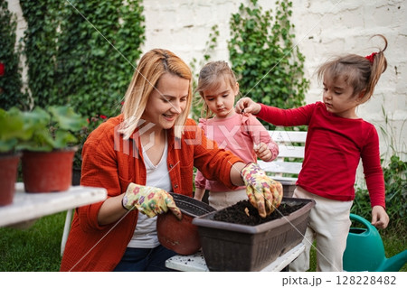 Gardening joy with children in a sunny backyard 128228482