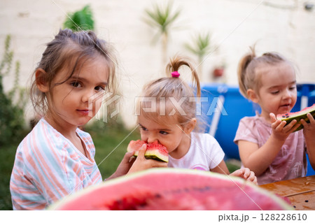 Enjoying summer delights with friends in a sunny backyard 128228610