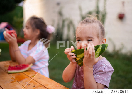 Joyful summer moments shared over fresh watermelon slices Joyful summer moments shared over fresh watermelon slices 128228616