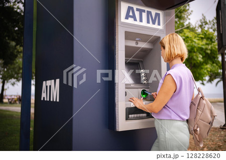 Exploring summer in Greece while visiting a local ATM 128228620