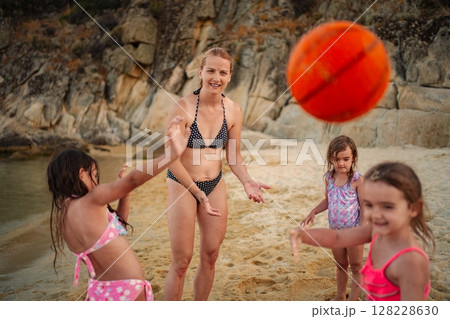 Family enjoys playful moments on the beach during sunset 128228630