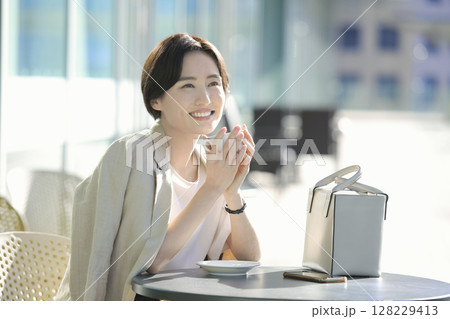 カフェテラスでコーヒブレイクをする女性 カフェテラスでコーヒブレイクをする女性 128229413