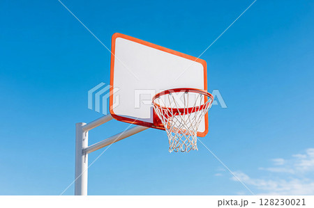 Basketball hoop against clear blue sky with bright sunlight illuminating the outdoor sports area during midday hours in a vibrant community setting Basketball hoop against clear blue sky with bright sunlight illuminating the outdoor sports area during midday hours in a vibrant community setting 128230021