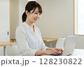笑顔でパソコンを使う女性 128230822