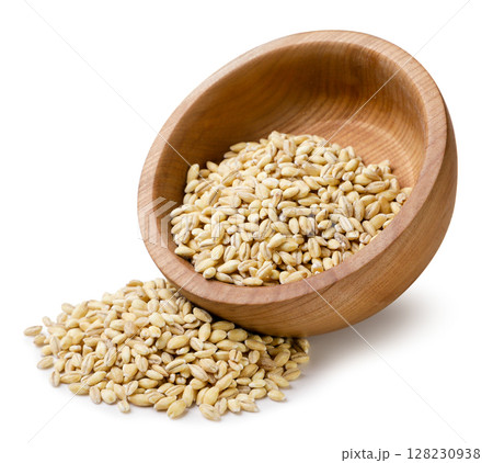 Pearl barley in a wooden plate and poured out close-up on a white. Isolated 128230938