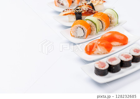 Assorted sushi and maki rolls beautifully arranged on plates Assorted sushi and maki rolls beautifully arranged on plates 128232685