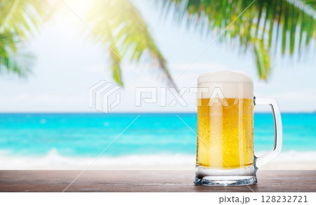 A glass of beer with a golden hue and frothy head 128232721