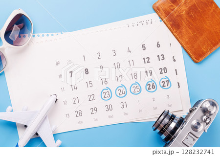 Travel-themed flat lay with calendar, toy airplane, camera, and sunglasses Travel-themed flat lay with calendar, toy airplane, camera, and sunglasses 128232741