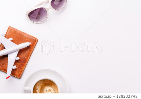 Travel-themed flat lay with toy airplane, camera, and coffee Travel-themed flat lay with toy airplane, camera, and coffee 128232745