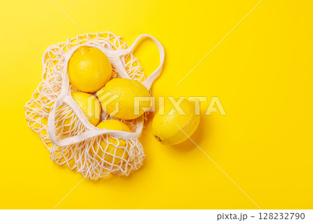 Fresh juicy lemons in a mesh bag, flat lay style 128232790