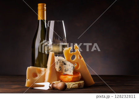 Assorted cheeses paired with glass of wine on a rustic table Assorted cheeses paired with glass of wine on a rustic table 128232811