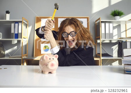 Crazy man wants to break his piggy bank with hammer and invest his money in business Crazy man wants to break his piggy bank with hammer and invest his money in business 128232961