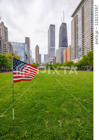 American flag on a green grass field surrounded by buildings in downtown Chicago American flag on a green grass field surrounded by buildings in downtown Chicago 128233567