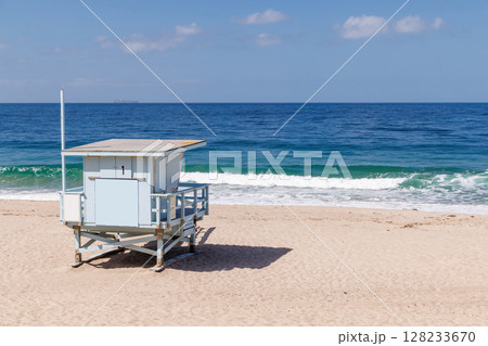 Lifeguard tower on a California ocean beach with golden sand and waves 128233670