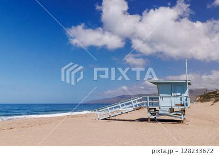 Lifeguard tower on a California ocean beach with golden sand and waves 128233672