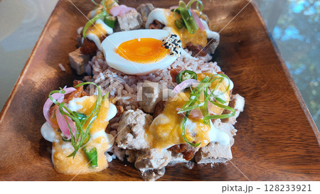Close up to a garnished and visually pleasing wooden plate of steamed rice, egg, fried tofu cubes and fried oyster mushroom showing a healthy vegetarian meal for health and wellness Close up to a garnished and visually pleasing wooden plate of steamed rice, egg, fried tofu cubes and fried oyster mushroom showing a healthy vegetarian meal for health and wellness 128233921