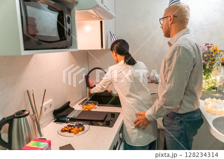 Couple Cooking Kitchen Apartment: Young couple prepares food in modern apartment kitchen; enjoying domestic life. 128234314