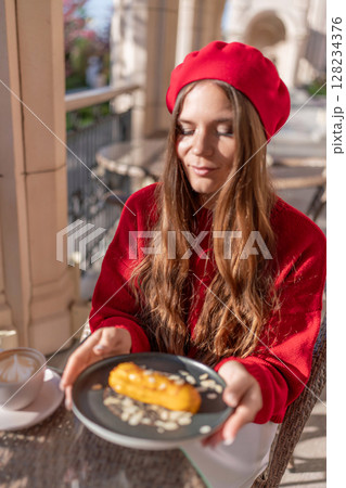 Woman Beret Eclair: Eating dessert at an outdoor cafe during a sunny morning, casual style. 128234376