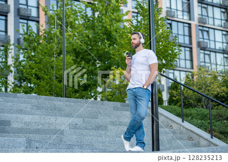 man in music headphones in the street with copy space. man in music headphones outside. man in music headphones in the street with copy space. man in music headphones outside. 128235213