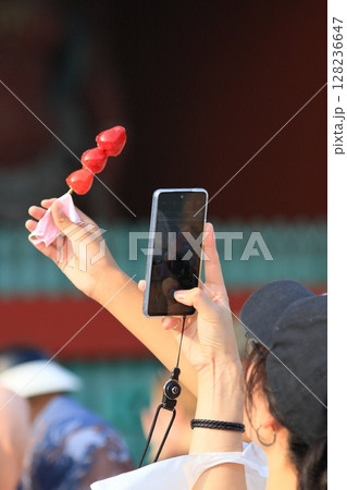 いちご飴の写真を撮る観光客 128236647