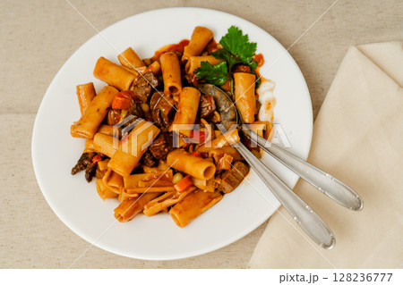 Delicious beef stew with rigatoni pasta and vegetables garnished with parsley Delicious beef stew with rigatoni pasta and vegetables garnished with parsley 128236777
