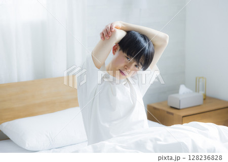 ベッドでストレッチする若い男性 ベッドでストレッチする若い男性 128236828
