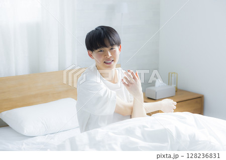 ベッドでストレッチする若い男性　 128236831