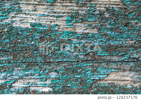 Textured weathered wood with peeling turquoise paint 128237176
