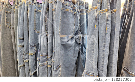 Variety of denim jeans hanging in a clothing store display 128237309