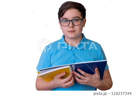 Young caucasian male teen holding notebooks in blue shirt isolated on black background 128237344