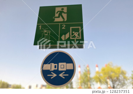 Emergency exit and seatbelt signs on clear sky background Emergency exit and seatbelt signs on clear sky background 128237351