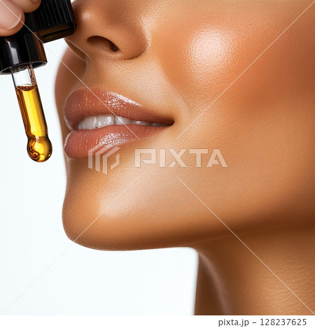Concept with a woman, applying oil with a pipette on the lips Concept with a woman, applying oil with a pipette on the lips 128237625