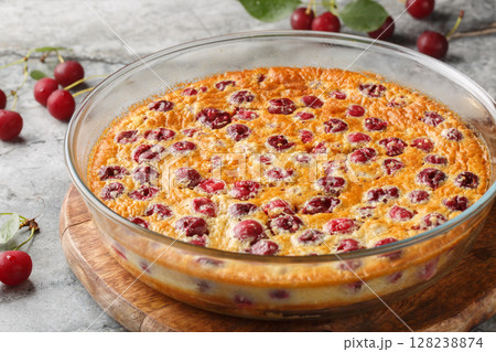 Homemade cherry clafoutis pie with fresh berries and vanilla close-up in a baking dish. Horizontal 128238874