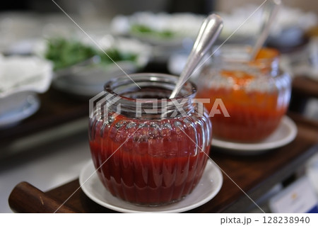 raspberry jam in a jar on a stool in a garden, selective focus raspberry jam in a jar on a stool in a garden, selective focus 128238940